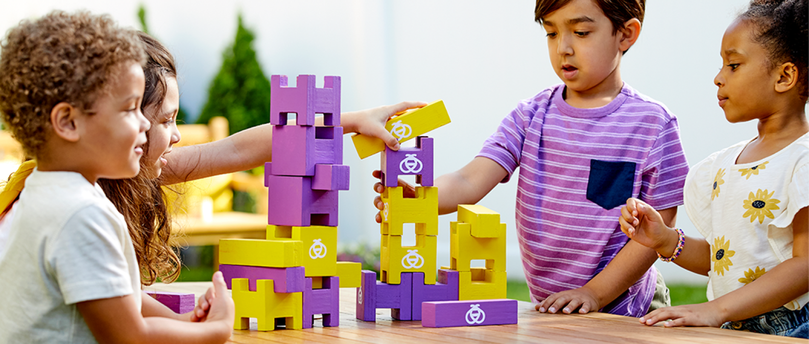 Children playing with purple and yellow building blocks together
